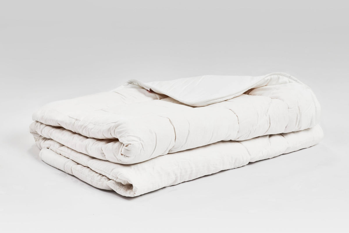 Gefaltete Zirbendecke Light mit feiner Steppung, naturweißem Baumwollbezug und leichter Füllung aus Tencel und Zirbenflocken – ideal für warme Nächte
